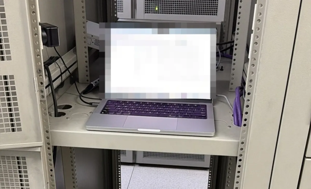 Technician working at the rack: laptop connected to the row switch, on top of a Dell server
