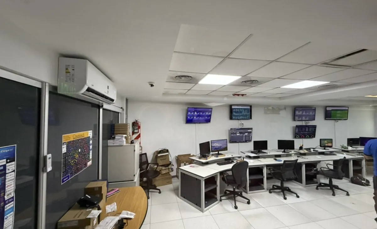Datacenter monitoring room: operator desks and status dashboards on the wall screens